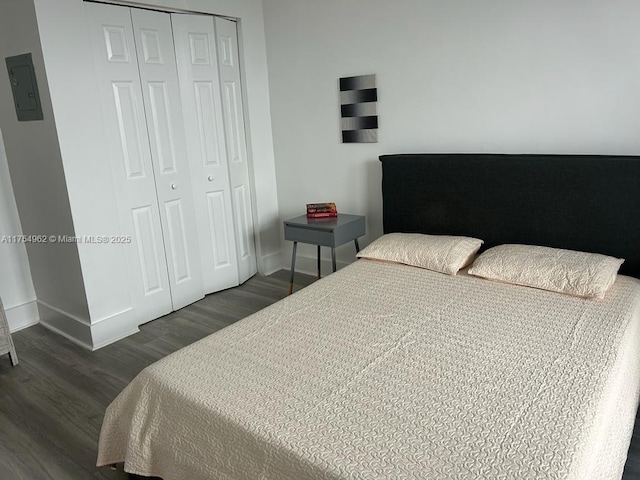 bedroom featuring a closet, wood finished floors, and baseboards