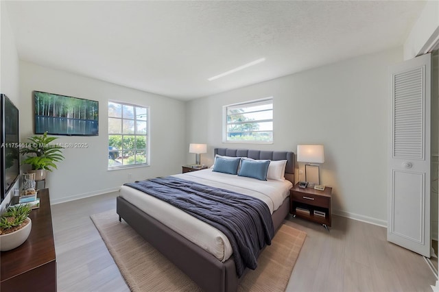 bedroom featuring baseboards and light wood-style floors