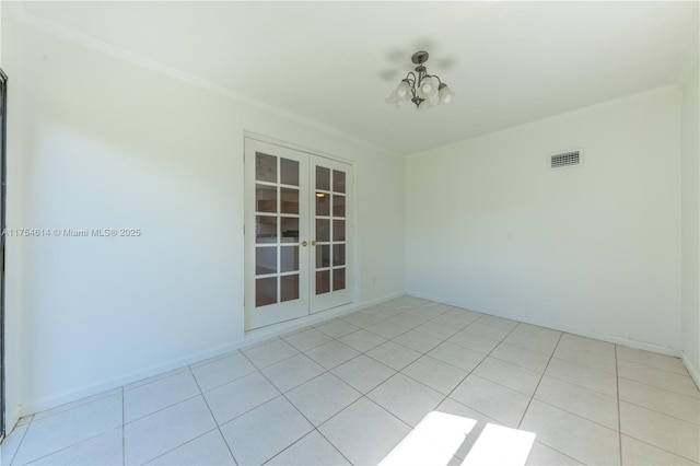 empty room with baseboards, visible vents, ornamental molding, and french doors