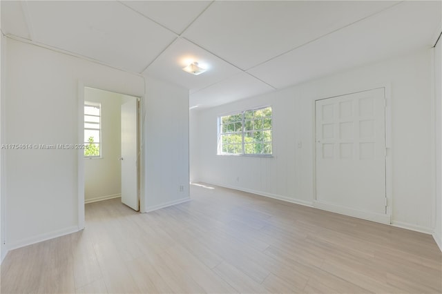 unfurnished room with light wood finished floors and baseboards