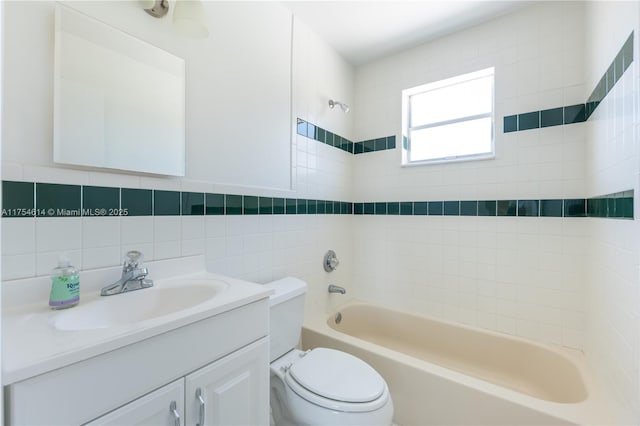 bathroom featuring toilet, vanity,  shower combination, and tile walls