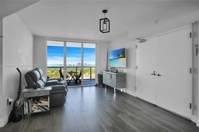 living room featuring dark wood-style floors, baseboards, and a wall of windows