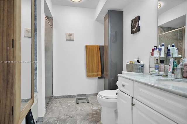 bathroom featuring toilet, a stall shower, vanity, and baseboards