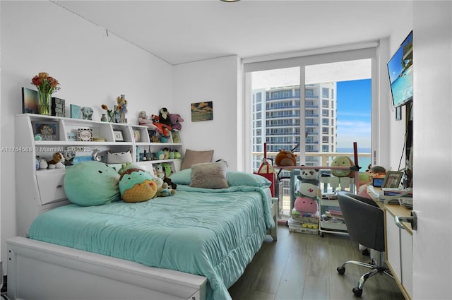 bedroom featuring expansive windows and wood finished floors