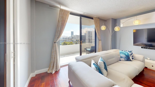 living area featuring floor to ceiling windows, a textured ceiling, baseboards, and wood finished floors