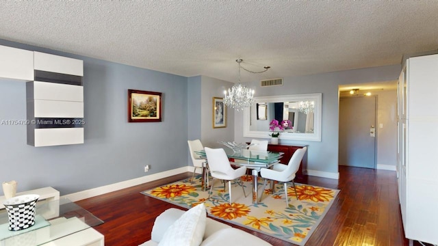 dining room featuring dark wood-style floors, baseboards, visible vents, a textured ceiling, and a chandelier