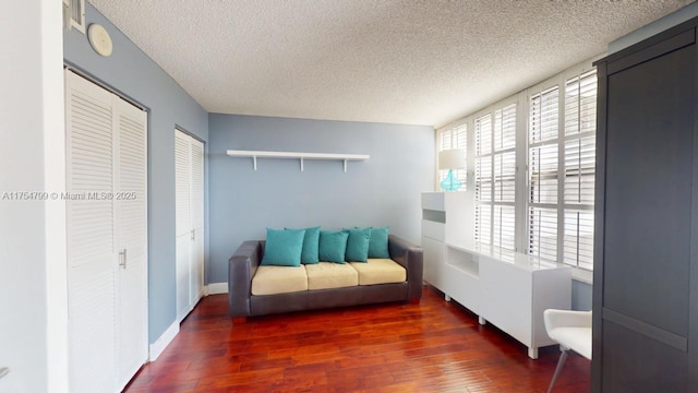 living area with a textured ceiling and wood finished floors