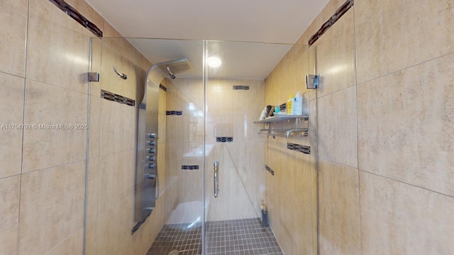 bathroom with a stall shower and tile walls