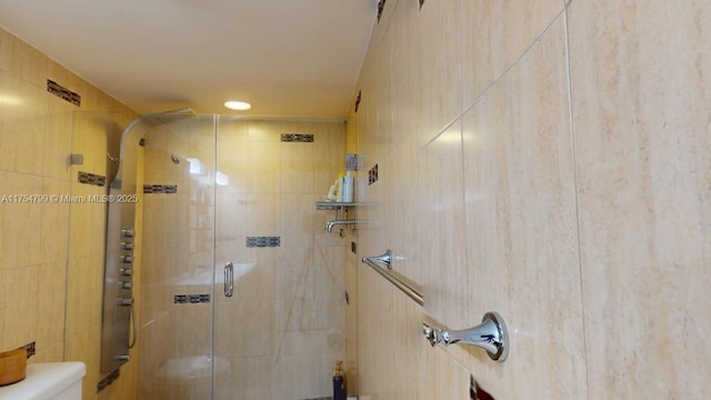 bathroom with a shower stall and toilet