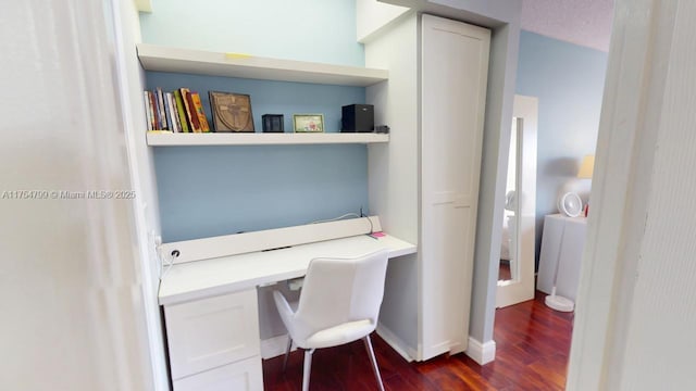 office space featuring baseboards, dark wood-style flooring, and built in desk