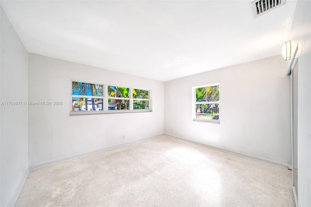 empty room with speckled floor and visible vents