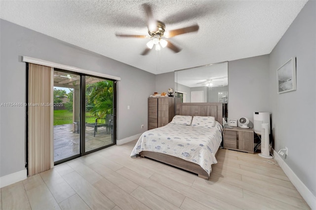 bedroom featuring access to exterior, light wood-style flooring, baseboards, and a textured ceiling