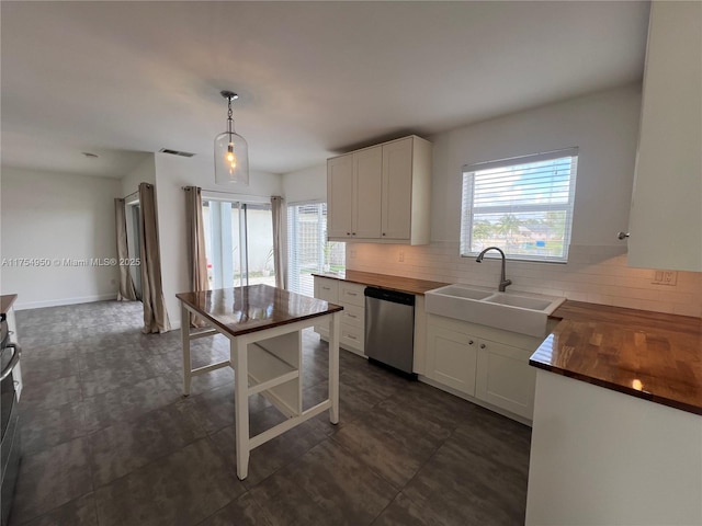 kitchen featuring butcher block countertops, a sink, decorative backsplash, and stainless steel dishwasher