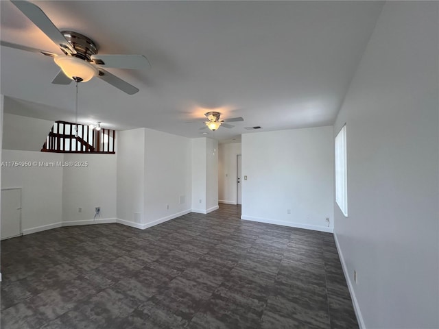 unfurnished room with visible vents, a ceiling fan, and baseboards