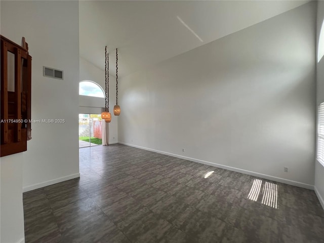 spare room featuring high vaulted ceiling, visible vents, and baseboards