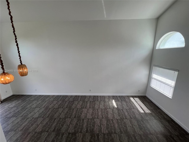 unfurnished room with a towering ceiling and baseboards