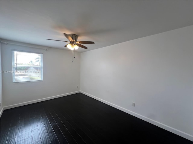 spare room with ceiling fan, dark wood-style flooring, and baseboards