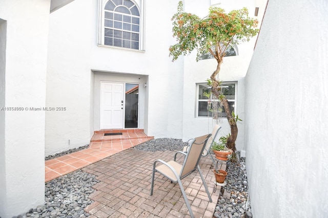 entrance to property with a patio area and stucco siding