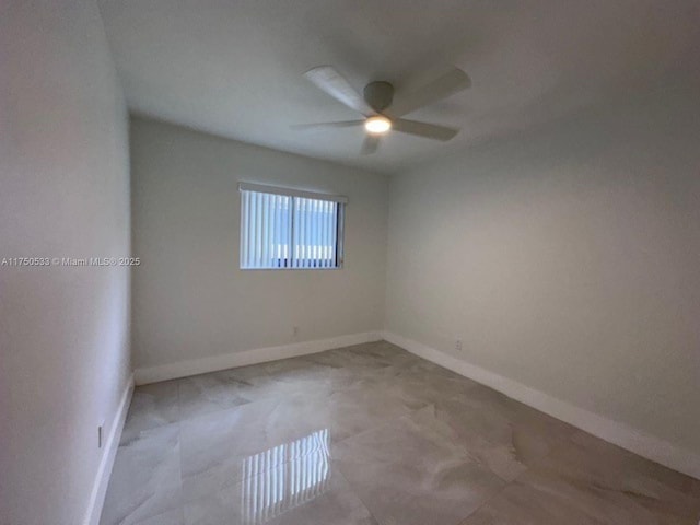 empty room featuring a ceiling fan and baseboards