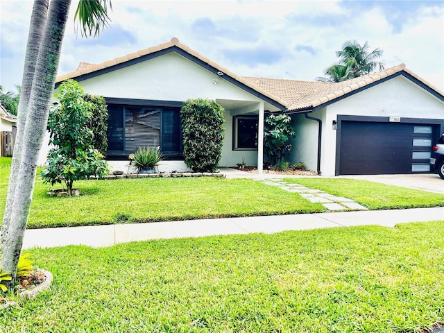 single story home with a garage, a tile roof, stucco siding, a front lawn, and driveway