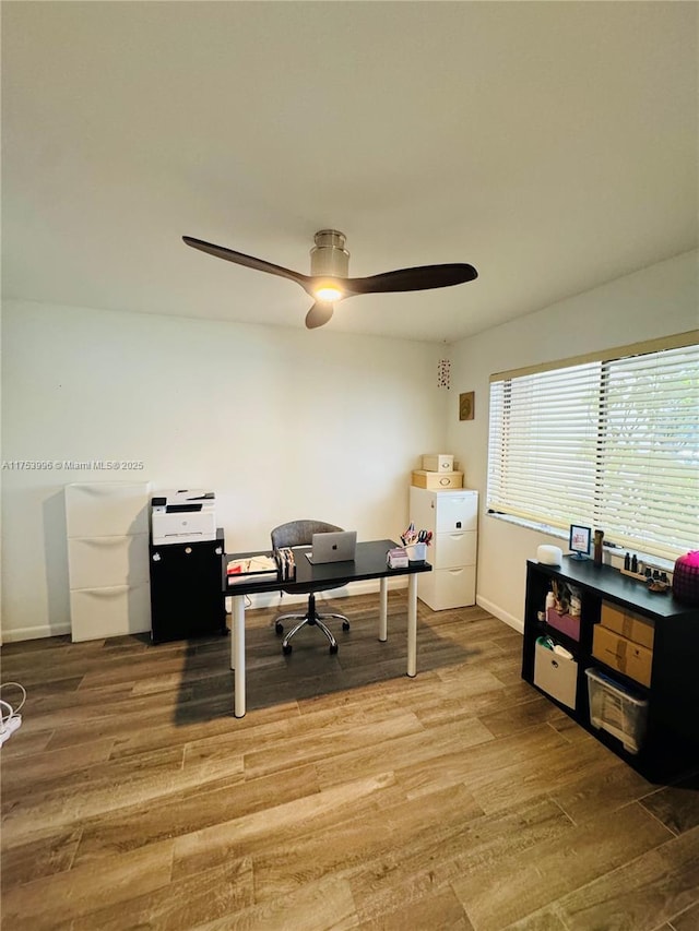 office space with baseboards, a ceiling fan, and wood finished floors