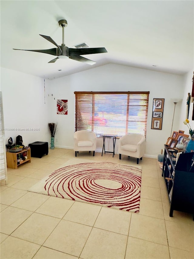 tiled living area with ceiling fan, lofted ceiling, baseboards, and a healthy amount of sunlight