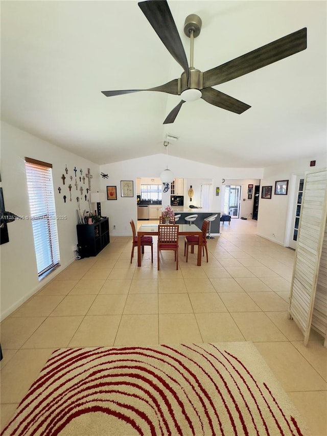 dining room with a wealth of natural light, light tile patterned floors, vaulted ceiling, and ceiling fan