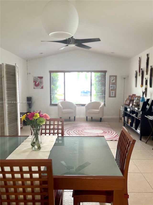 dining space featuring light tile patterned flooring, vaulted ceiling, and ceiling fan