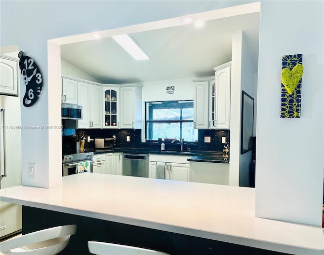 kitchen with a sink, tasteful backsplash, a kitchen breakfast bar, and stainless steel appliances
