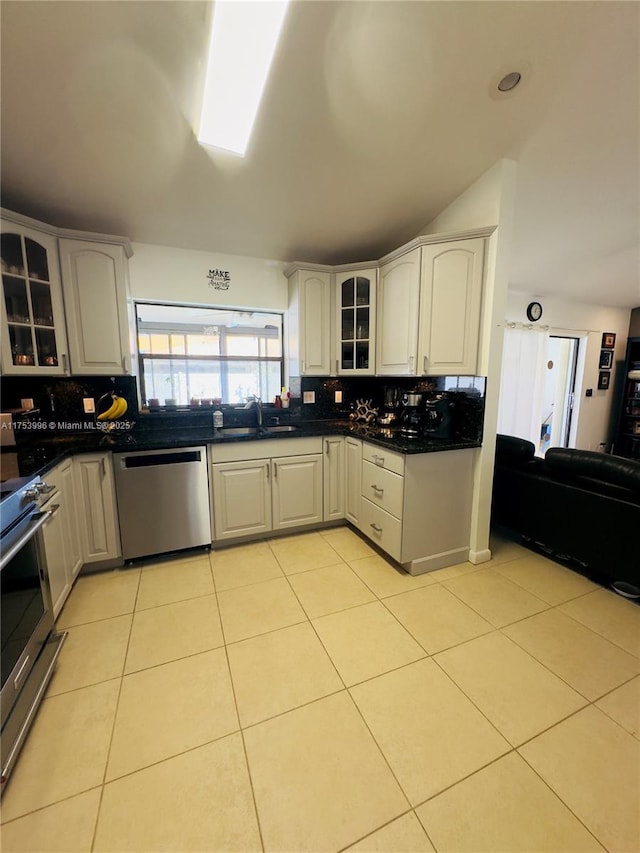 kitchen with a sink, decorative backsplash, appliances with stainless steel finishes, and dark countertops