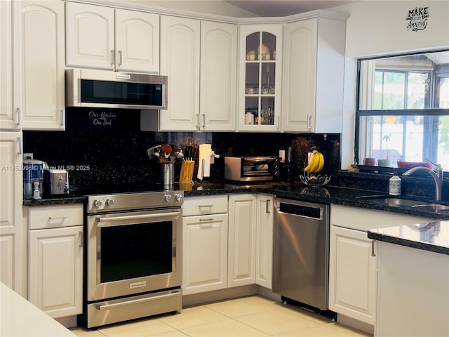kitchen with a sink, appliances with stainless steel finishes, a toaster, and white cabinetry