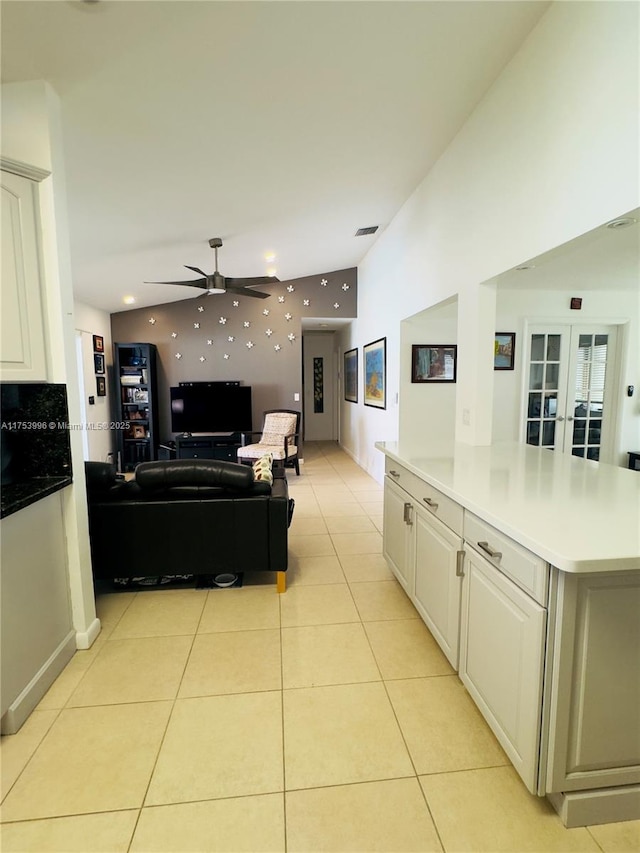 kitchen featuring light tile patterned floors, visible vents, open floor plan, light countertops, and a ceiling fan