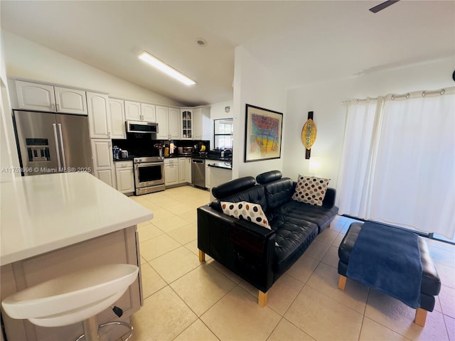 living area with light tile patterned floors and lofted ceiling
