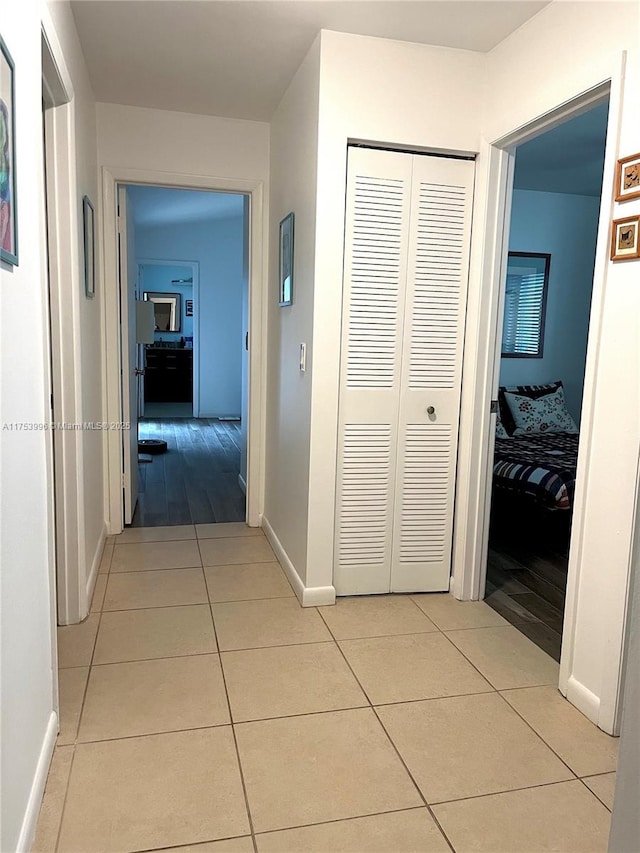 hallway with light tile patterned floors and baseboards