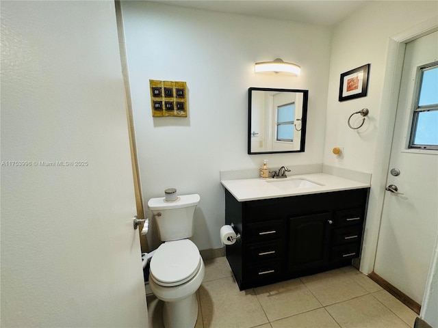 bathroom featuring toilet, tile patterned floors, vanity, and baseboards