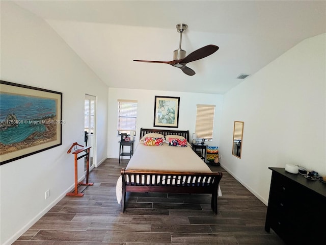 bedroom with wood finished floors, visible vents, baseboards, and lofted ceiling