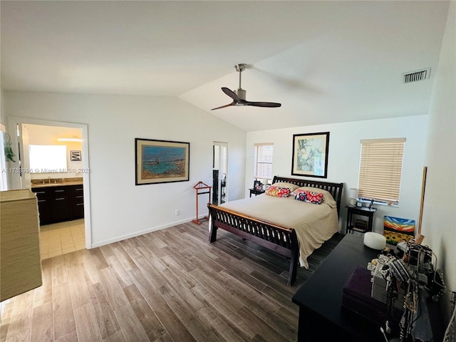 bedroom with visible vents, a ceiling fan, light wood finished floors, ensuite bath, and lofted ceiling