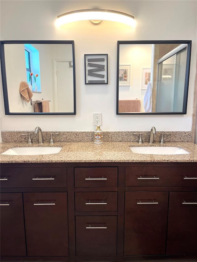 full bathroom featuring a sink, double vanity, and a stall shower