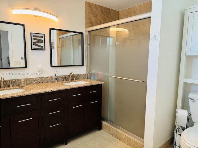 bathroom featuring toilet, a sink, and a shower stall