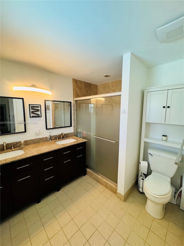 bathroom featuring toilet, double vanity, a sink, and a shower stall