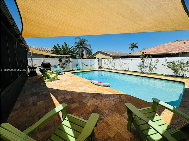 view of swimming pool featuring a fenced in pool, a patio, and a fenced backyard