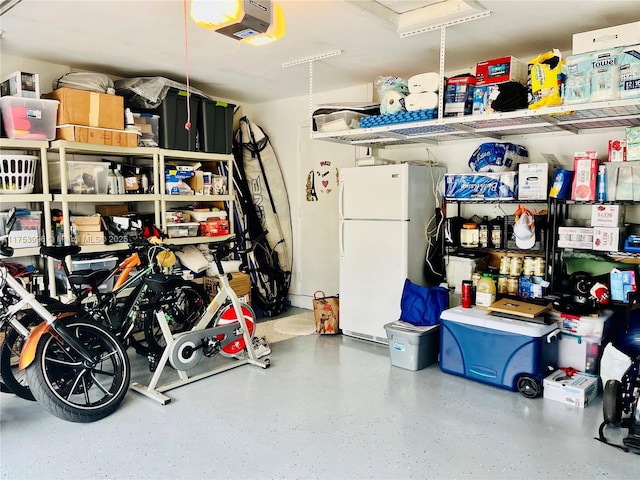garage with a garage door opener and freestanding refrigerator