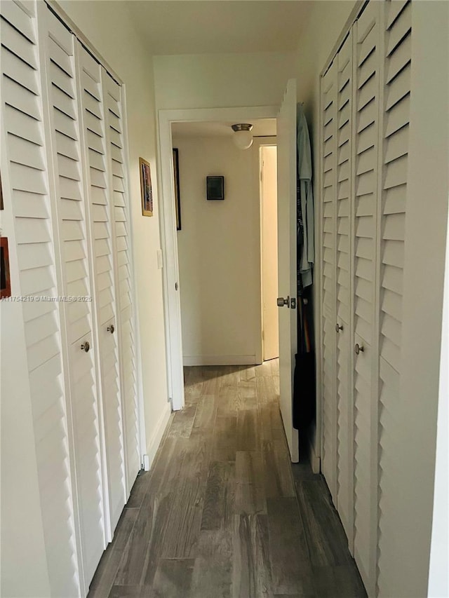 hallway with dark wood-style floors and baseboards