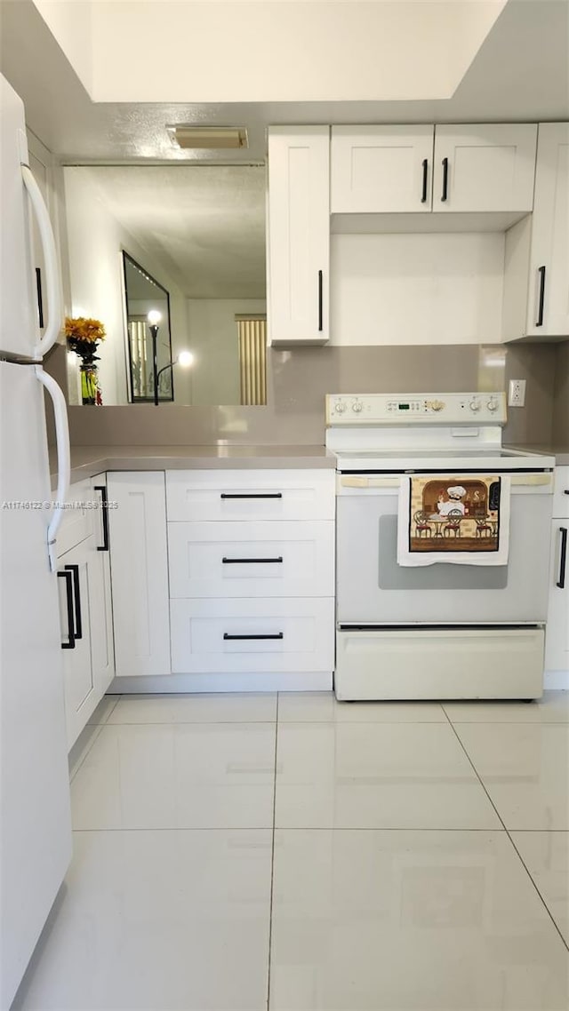 kitchen with white cabinets, white appliances, light tile patterned floors, and light countertops