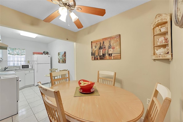 dining room with light tile patterned floors and a ceiling fan