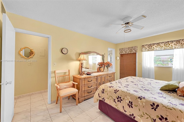 bedroom with light tile patterned floors, ceiling fan, and a textured ceiling