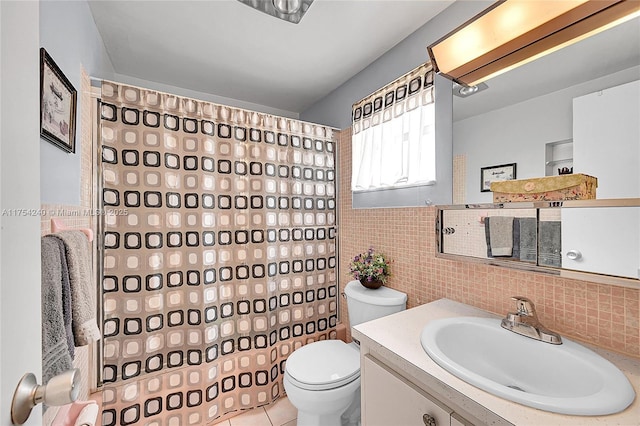 bathroom featuring tile patterned flooring, toilet, vanity, tile walls, and a shower