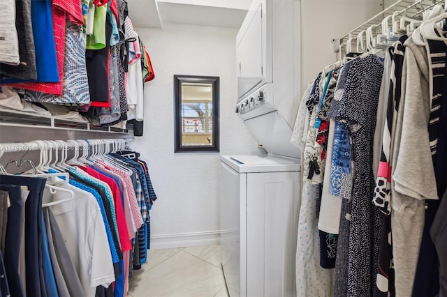 spacious closet with stacked washing maching and dryer and light tile patterned floors