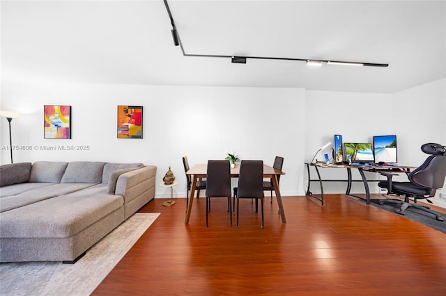 dining room with track lighting and wood finished floors