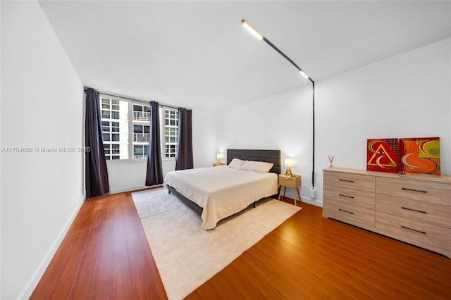 bedroom with baseboards and hardwood / wood-style flooring